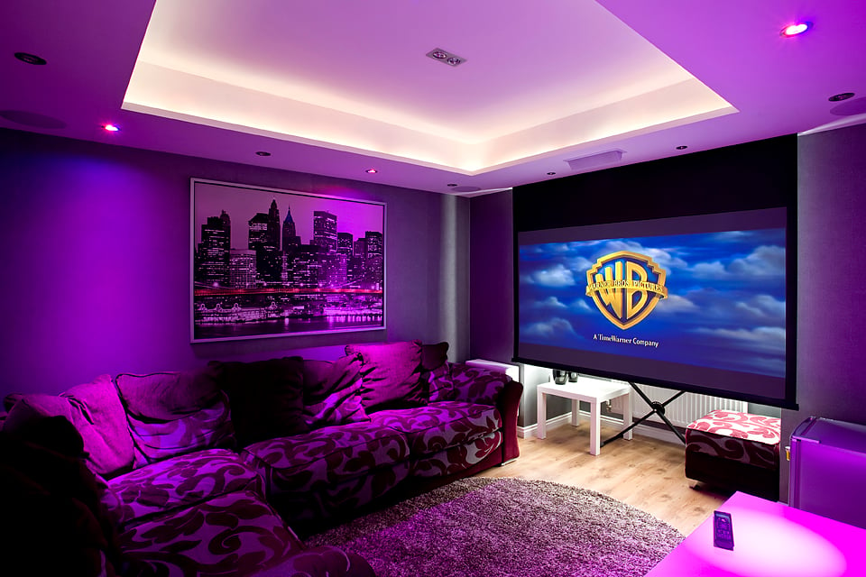 recessed projector screen showing warner bros logo in living room purple lights