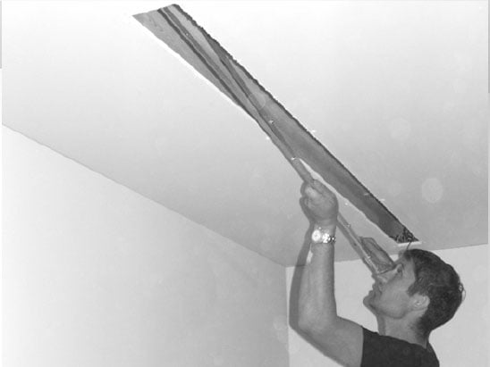 man installing ceiling recessed projector screen
