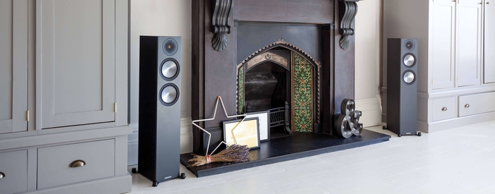 Monitor Audio Bronze 200 Floorstanding Speakers beside fireplace 