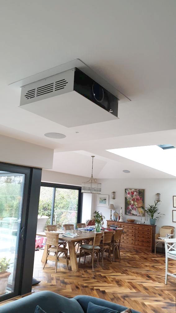 Projector lift coming out of ceiling in bright kitchen living room extension