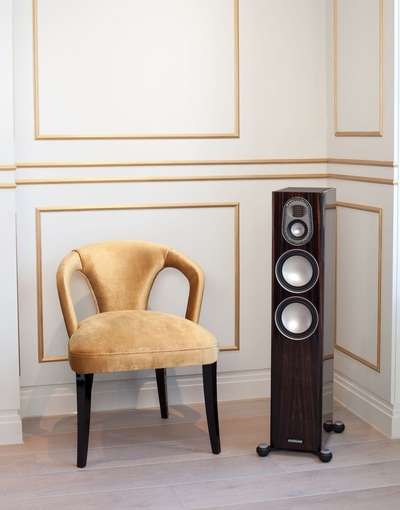 Monitor Audio Gold 200 Floorstanding Speakers beside a chair